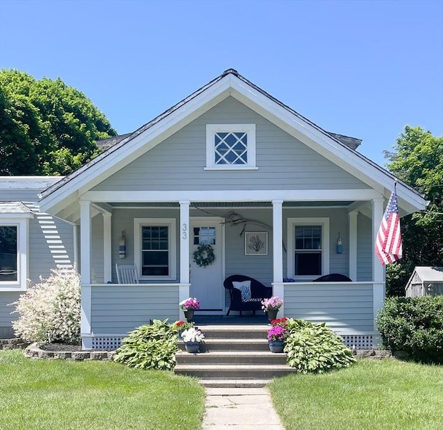 bungalow-style home featuring a porch and a front lawn