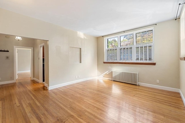 unfurnished room featuring light hardwood / wood-style floors and radiator