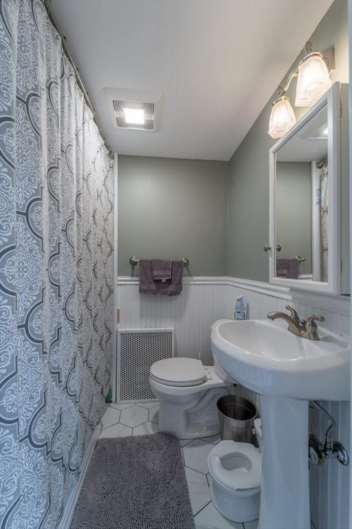 1349 Main St, Holden, MA 01520 - full bathroom with tile patterned floors, toilet, a wainscoted wall, and a shower with shower curtain