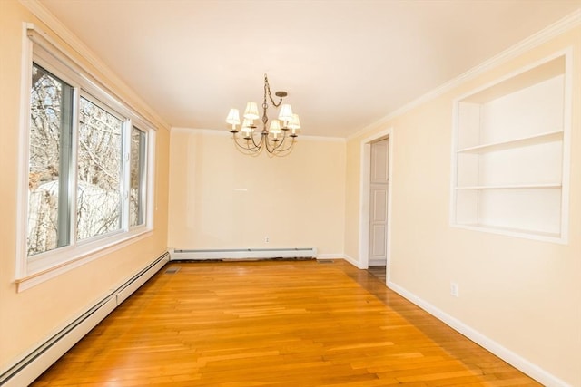 empty room featuring built in shelves, ornamental molding, a baseboard heating unit, light wood finished floors, and baseboards