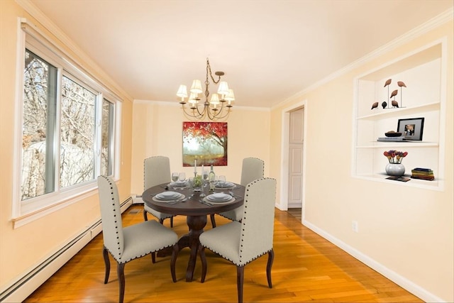 dining space with light wood-type flooring, an inviting chandelier, ornamental molding, and a baseboard radiator