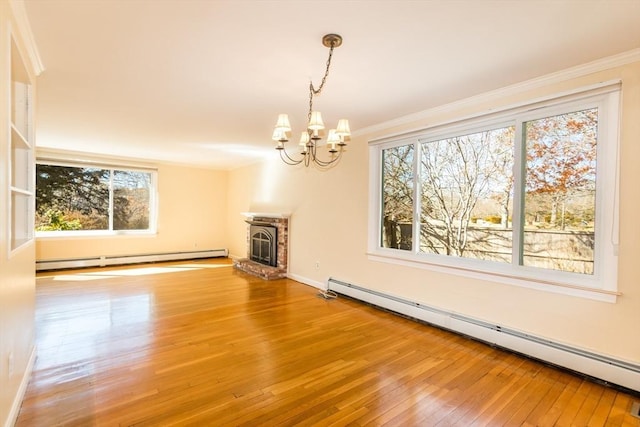 spare room featuring baseboard heating, wood-type flooring, and ornamental molding