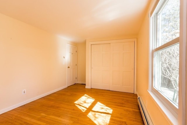 empty room with plenty of natural light, light wood-type flooring, and baseboards