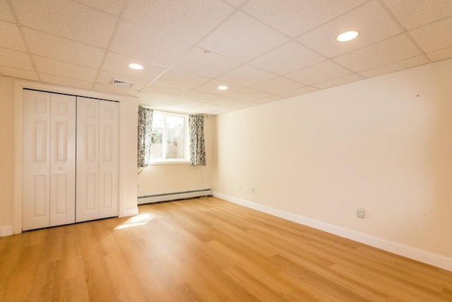 unfurnished bedroom featuring visible vents, baseboards, light wood-style floors, and a baseboard radiator