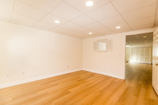 spare room with recessed lighting, baseboards, light wood-type flooring, and a paneled ceiling