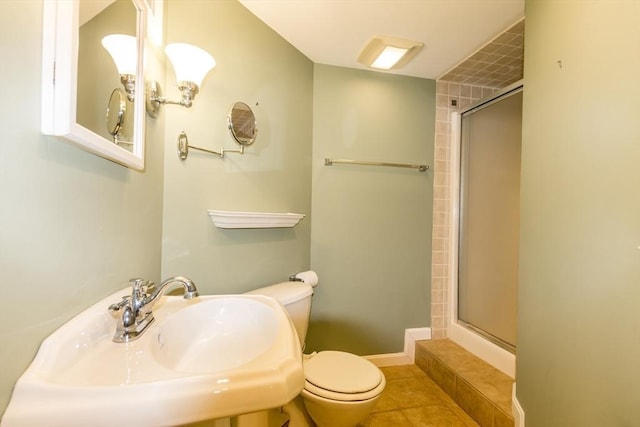 full bath featuring baseboards, a sink, tile patterned flooring, a shower stall, and toilet