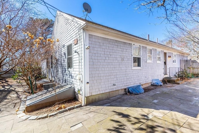 view of property exterior featuring a patio and fence