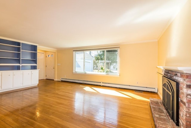 unfurnished living room with a baseboard heating unit, light wood-style flooring, a fireplace, and crown molding