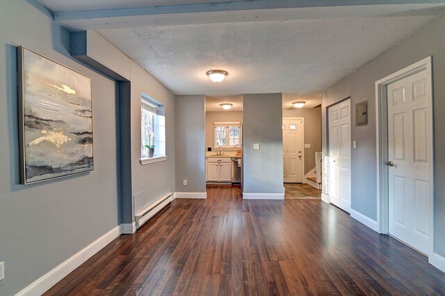 interior space with a baseboard heating unit, dark hardwood / wood-style flooring, a textured ceiling, sink, and ensuite bathroom