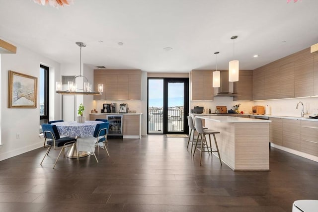 14 W Broadway Unit 903, Boston, MA 02127 - kitchen with modern cabinets, wine cooler, wall chimney exhaust hood, a kitchen island, and a breakfast bar area