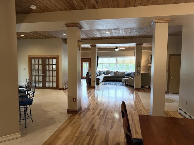 3 Wolf Rd, Bourne, MA 02532 - hall with decorative columns, a baseboard heating unit, wood ceiling, baseboards, and light wood finished floors