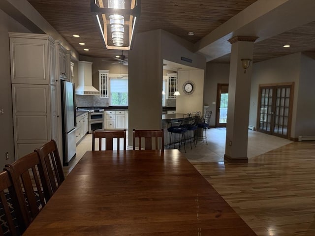 3 Wolf Rd, Bourne, MA 02532 - dining space featuring light wood finished floors, a baseboard heating unit, wood ceiling, a ceiling fan, and decorative columns