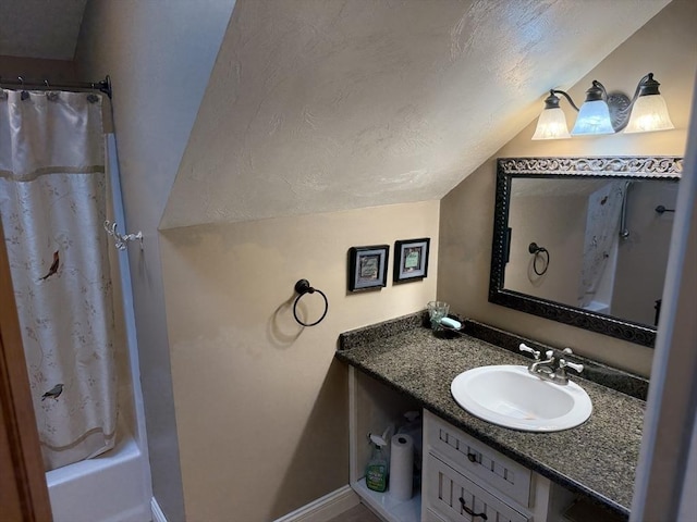 3 Wolf Rd, Bourne, MA 02532 - bathroom with vaulted ceiling, vanity, a textured ceiling, baseboards, and shower / bath combo with shower curtain