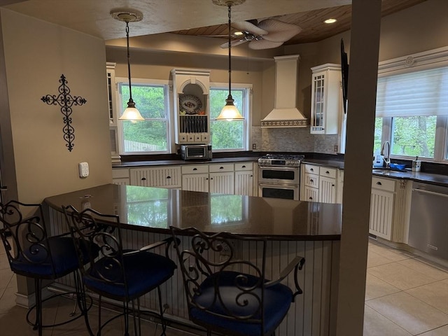3 Wolf Rd, Bourne, MA 02532 - kitchen featuring custom exhaust hood, appliances with stainless steel finishes, dark countertops, and light tile patterned floors