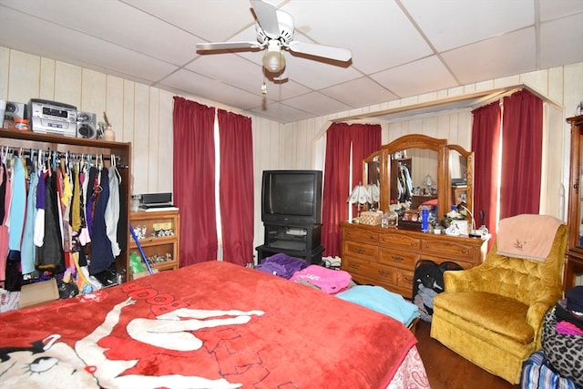 bedroom with a closet, a paneled ceiling, wood-type flooring, and ceiling fan