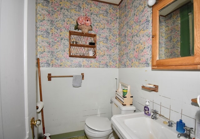 bathroom featuring tile walls, sink, and toilet