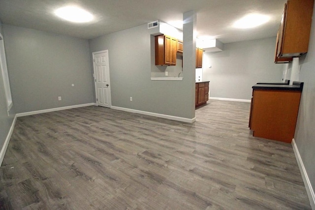 interior space featuring visible vents, baseboards, and dark wood finished floors