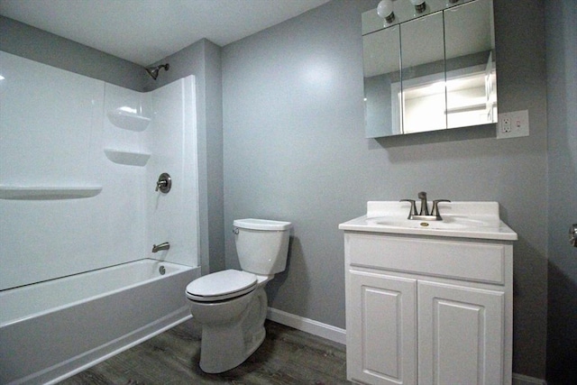bathroom featuring toilet, wood finished floors, vanity, and baseboards