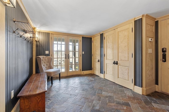 unfurnished room featuring french doors, baseboards, and stone tile floors