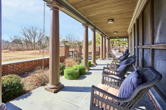 view of patio featuring covered porch and fence