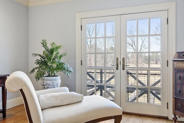 doorway featuring french doors, baseboards, light wood finished floors, and ornamental molding