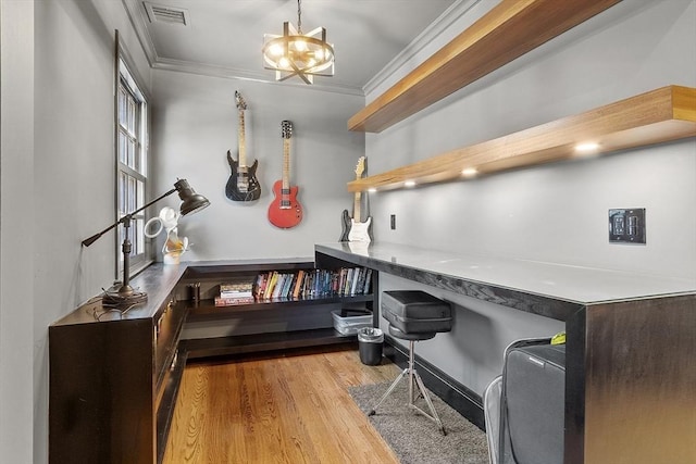 office space with visible vents, wood finished floors, an inviting chandelier, and ornamental molding