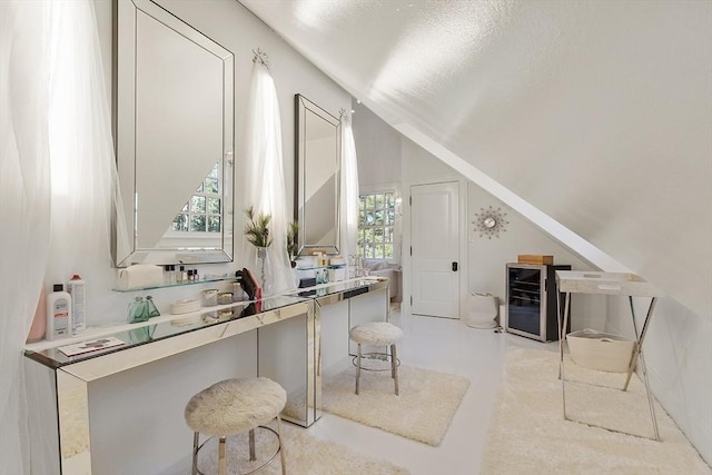 office space featuring vaulted ceiling and beverage cooler