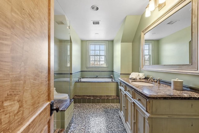 bathroom featuring visible vents, a bath, and vanity