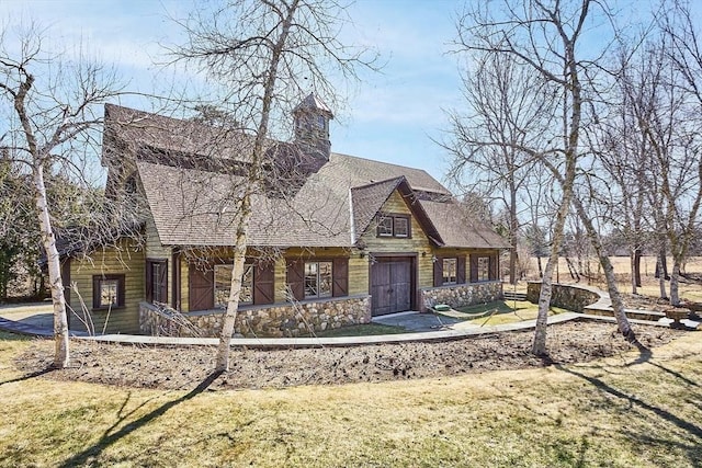 view of front of property with stone siding, roof with shingles, and a front yard