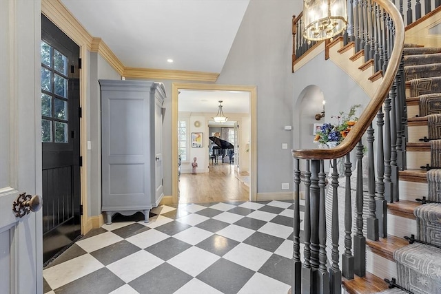 foyer with crown molding, baseboards, stairway, arched walkways, and tile patterned floors