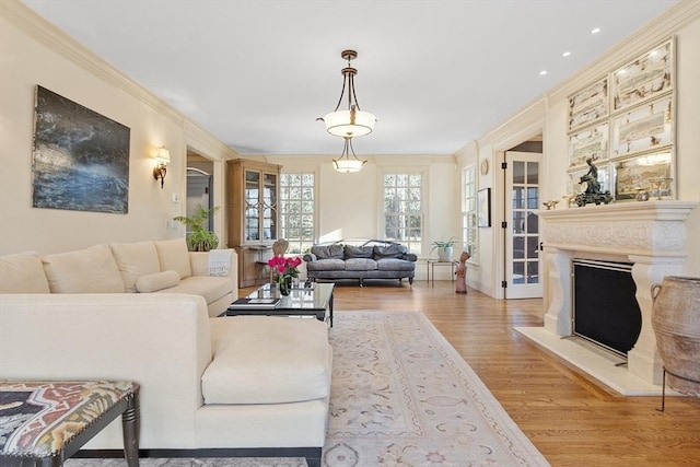 living room with a fireplace, wood finished floors, and ornamental molding