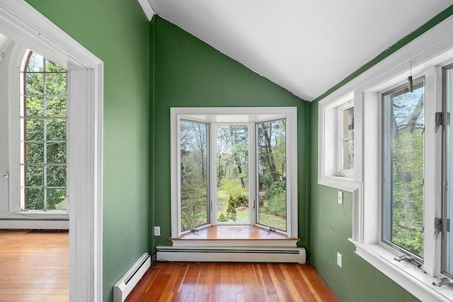unfurnished sunroom with a baseboard radiator, healthy amount of natural light, and lofted ceiling