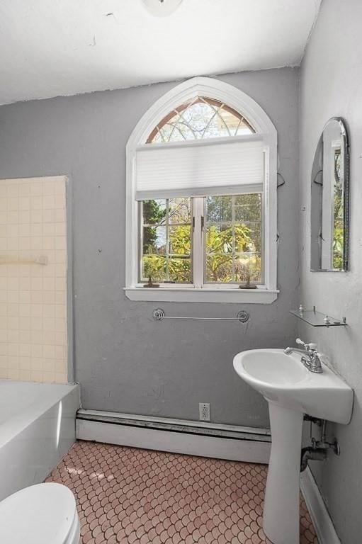 full bath featuring baseboard heating, toilet, and a bath