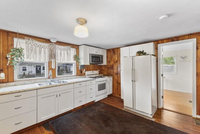 34 13th St, Wareham, MA 02532 - kitchen with white appliances, a sink, dark wood-style floors, white cabinetry, and wood walls