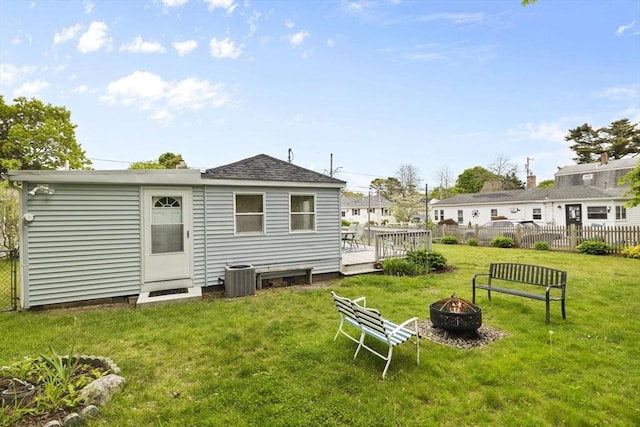 34 13th St, Wareham, MA 02532 - back of property with an outdoor fire pit, a wooden deck, central AC unit, and roof with shingles