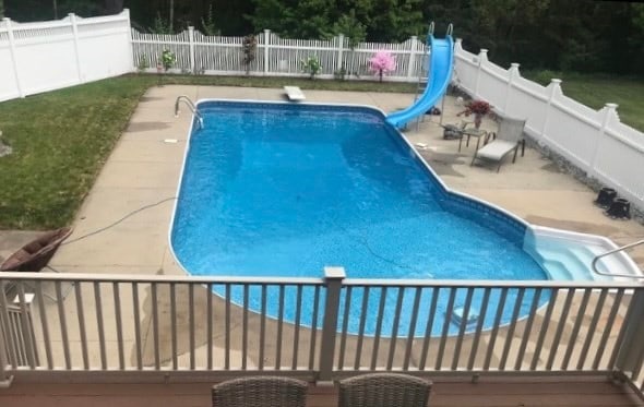 view of swimming pool featuring a diving board, a water slide, and a patio area