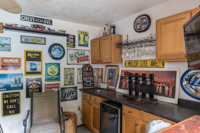 kitchen featuring beverage cooler and a textured ceiling