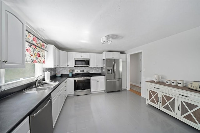 47 Pheasant Hill Rd, Weymouth, MA 02190 - kitchen with stainless steel appliances, dark countertops, tasteful backsplash, white cabinets, and light tile patterned flooring