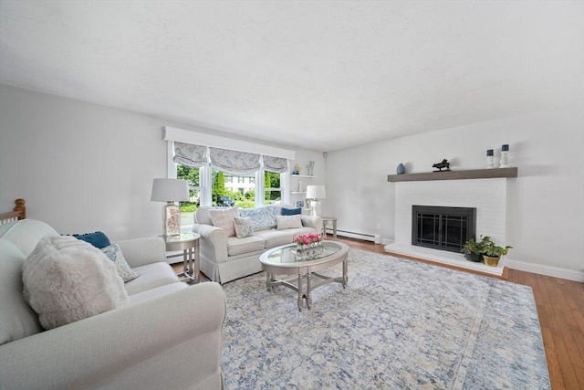 47 Pheasant Hill Rd, Weymouth, MA 02190 - living room with wood finished floors, a baseboard heating unit, a brick fireplace, and a baseboard radiator