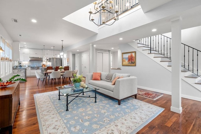 living room featuring dark wood finished floors, a notable chandelier, recessed lighting, visible vents, and stairs