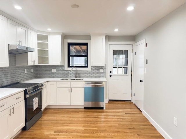 kitchen with stainless steel appliances, tasteful backsplash, sink, and white cabinets