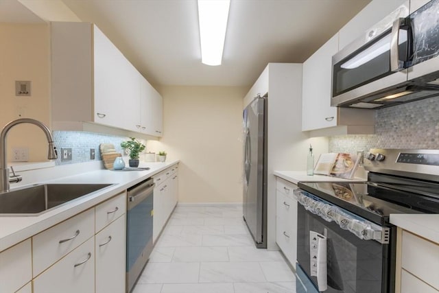 kitchen featuring stainless steel appliances, sink, decorative backsplash, and white cabinets