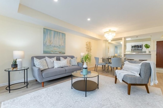 living room featuring a chandelier and light wood-type flooring