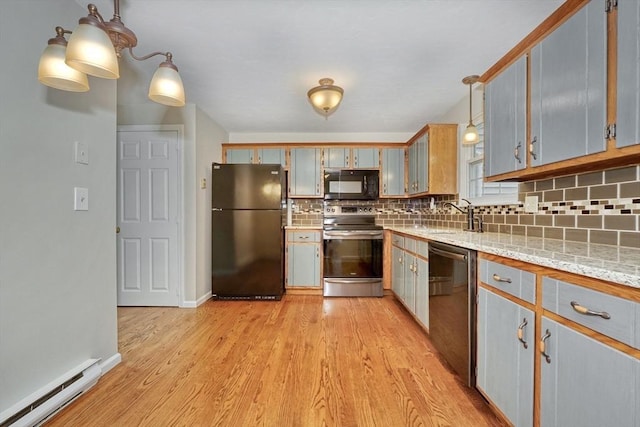 47 Key St Unit 47, Millis, MA 02054 - kitchen with appliances with stainless steel finishes, a baseboard heating unit, tasteful backsplash, light wood finished floors, and hanging light fixtures
