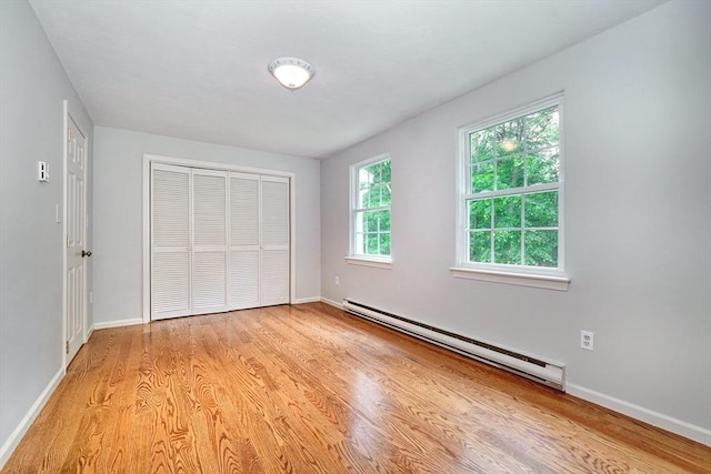 47 Key St Unit 47, Millis, MA 02054 - unfurnished bedroom with a baseboard heating unit, a closet, and light wood-type flooring