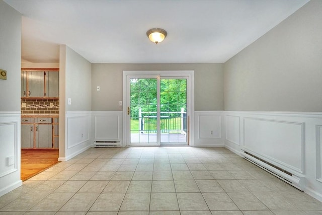 47 Key St Unit 47, Millis, MA 02054 - empty room with a decorative wall, a wainscoted wall, a baseboard radiator, light tile patterned flooring, and a baseboard heating unit