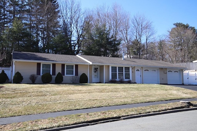 single story home featuring an attached garage, driveway, a front yard, and fence