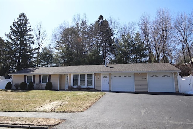 ranch-style house featuring aphalt driveway, a garage, a front yard, and fence