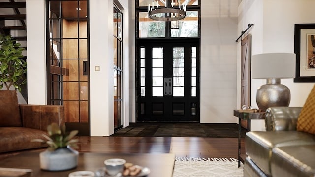 foyer entrance with a barn door, a chandelier, and dark wood-type flooring