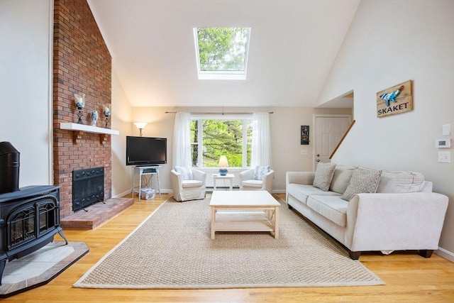 94 Pine View Dr, Brewster, MA 02631 - living area featuring a skylight, wood finished floors, high vaulted ceiling, and a wood stove